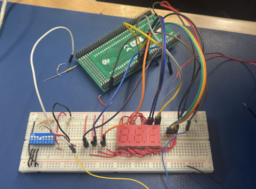 Breadboard 7-segment display prototype — DIP switches, transistors, dev board harness.